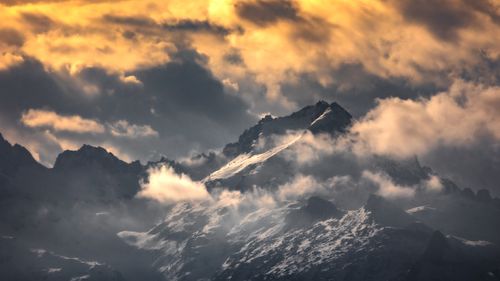 Free Stunning view of a mountain range in Italy with dramatic clouds and sunset light. Stock Photo