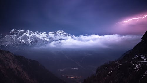 Snow Covered Mountains Over a Thunder and Lightning Photo