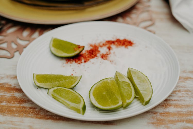 Sliced Limes On White Ceramic Plate