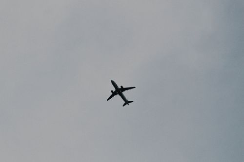 Free Low angle view of airplane silhouette flying through a clear sky, capturing the essence of travel and aviation. Stock Photo