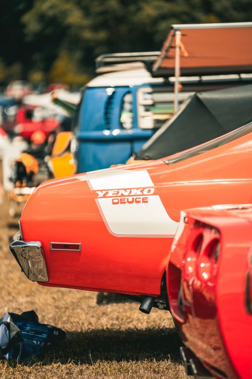 Free Close-up of a classic Yenko Deuce car in vibrant red at an outdoor automotive show. Stock Photo