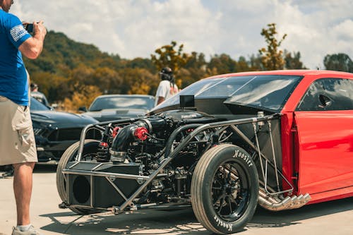 Man Photographing a Tuned Engine of a Racecar