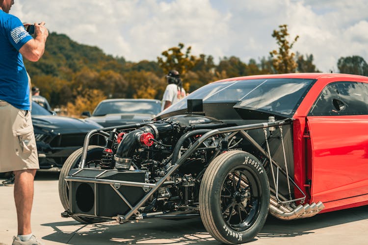 Man Photographing A Tuned Engine Of A Racecar