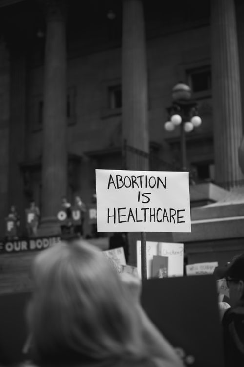 Free Protest sign stating 'Abortion is Healthcare' outside monumental building. Stock Photo