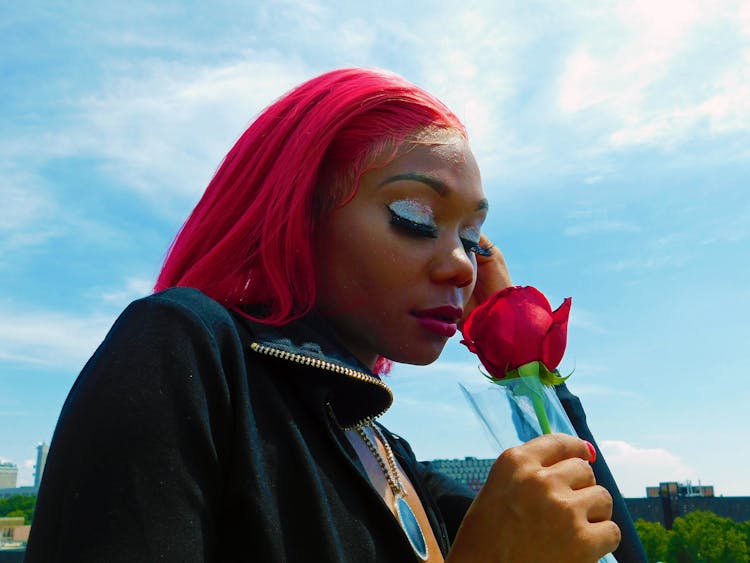 Woman In Black Jacket Holding A Red Rose