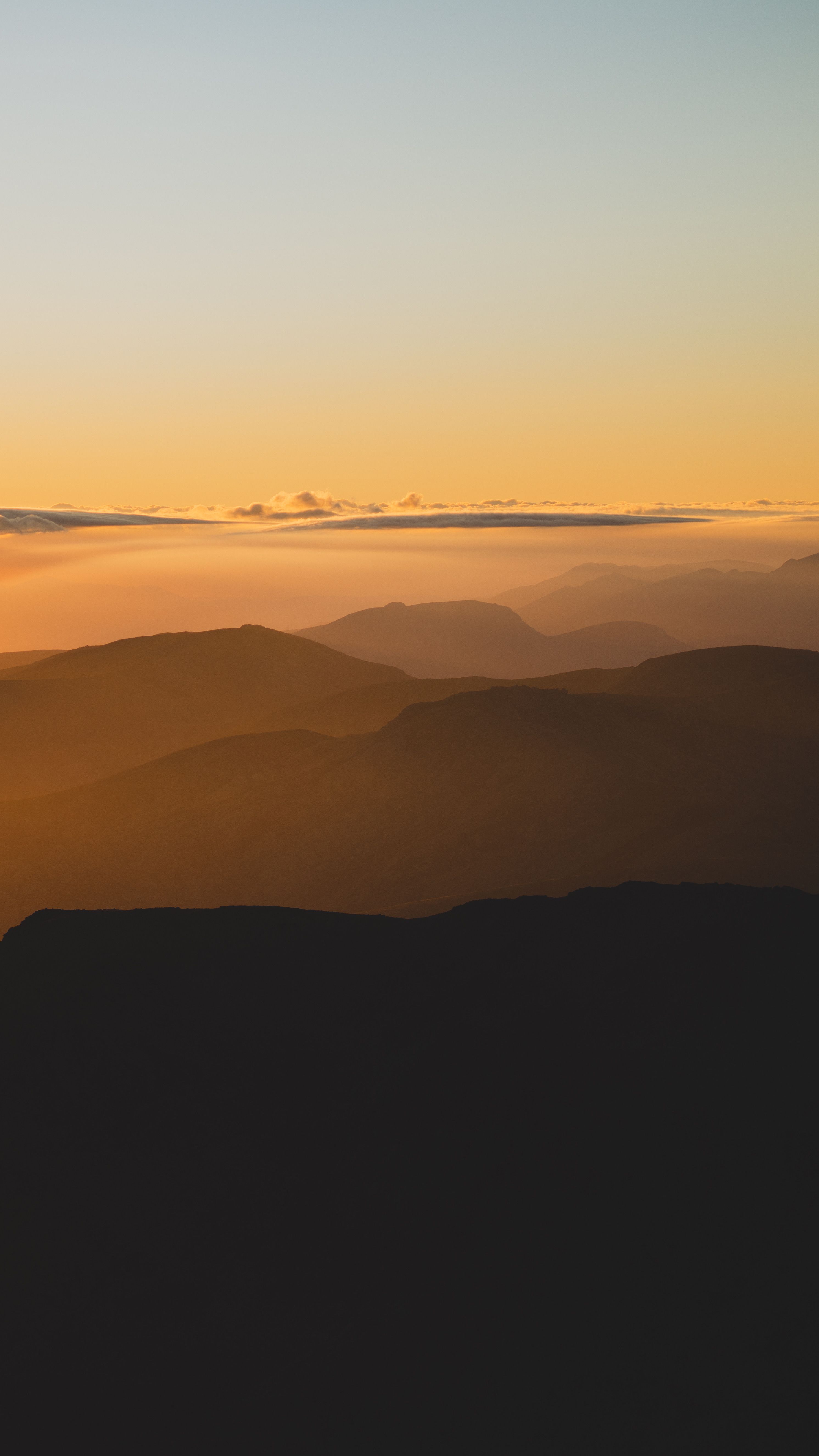 Peaceful mountain scape with a stunning sunset sky, perfect for tranquility and nature themes.