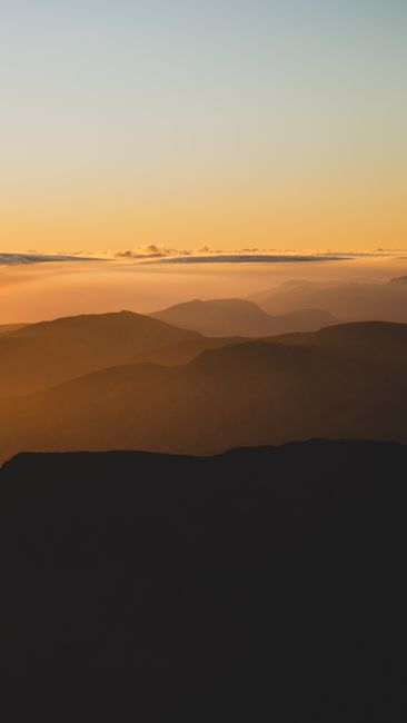 Peaceful mountain scape with a stunning sunset sky, perfect for tranquility and nature themes.