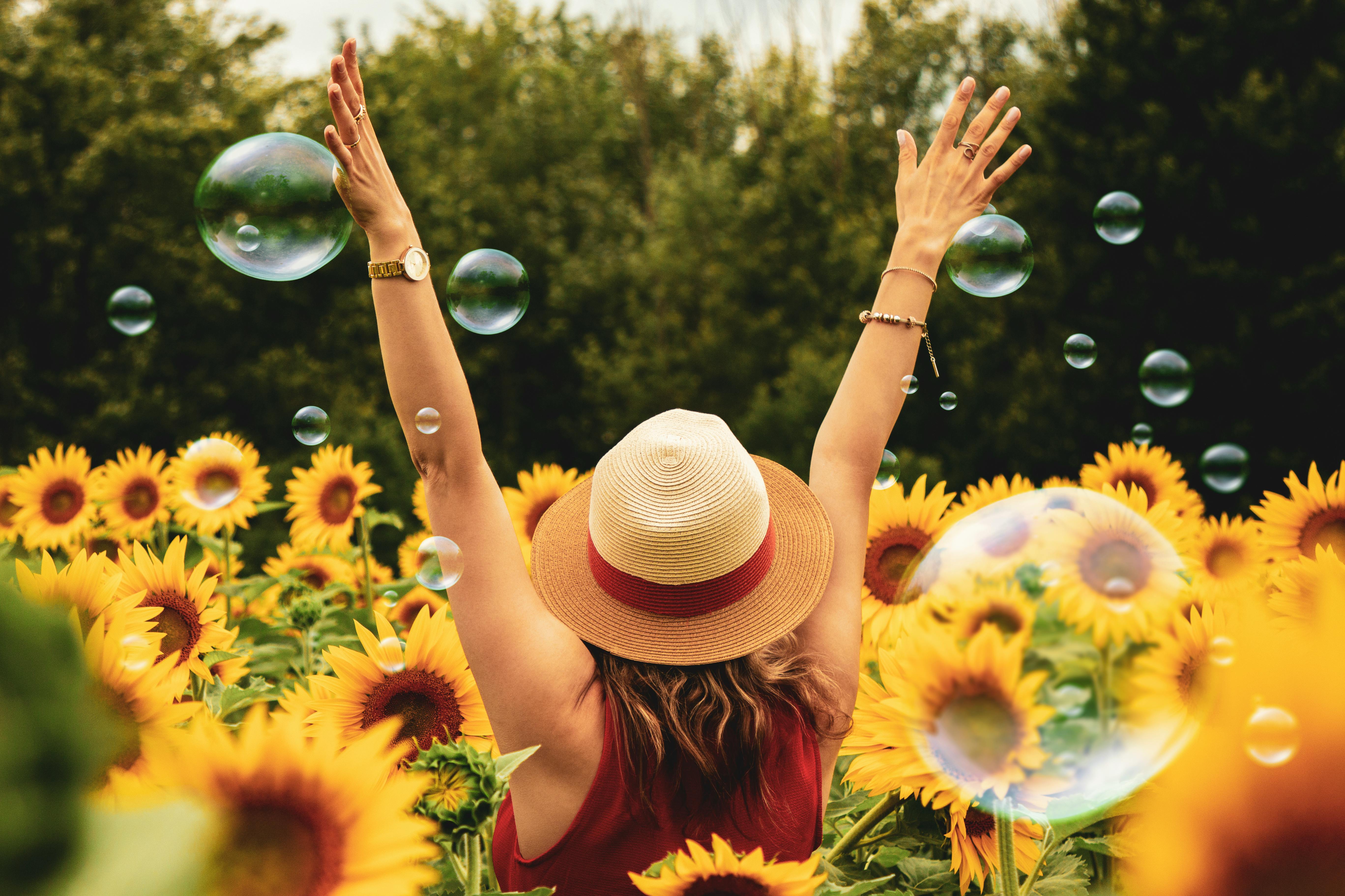 Woman surrounded by sunflowers. | Photo: Pexels