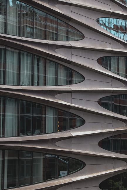 Close-up view of a futuristic glass facade in New York City's modern architecture landscape.