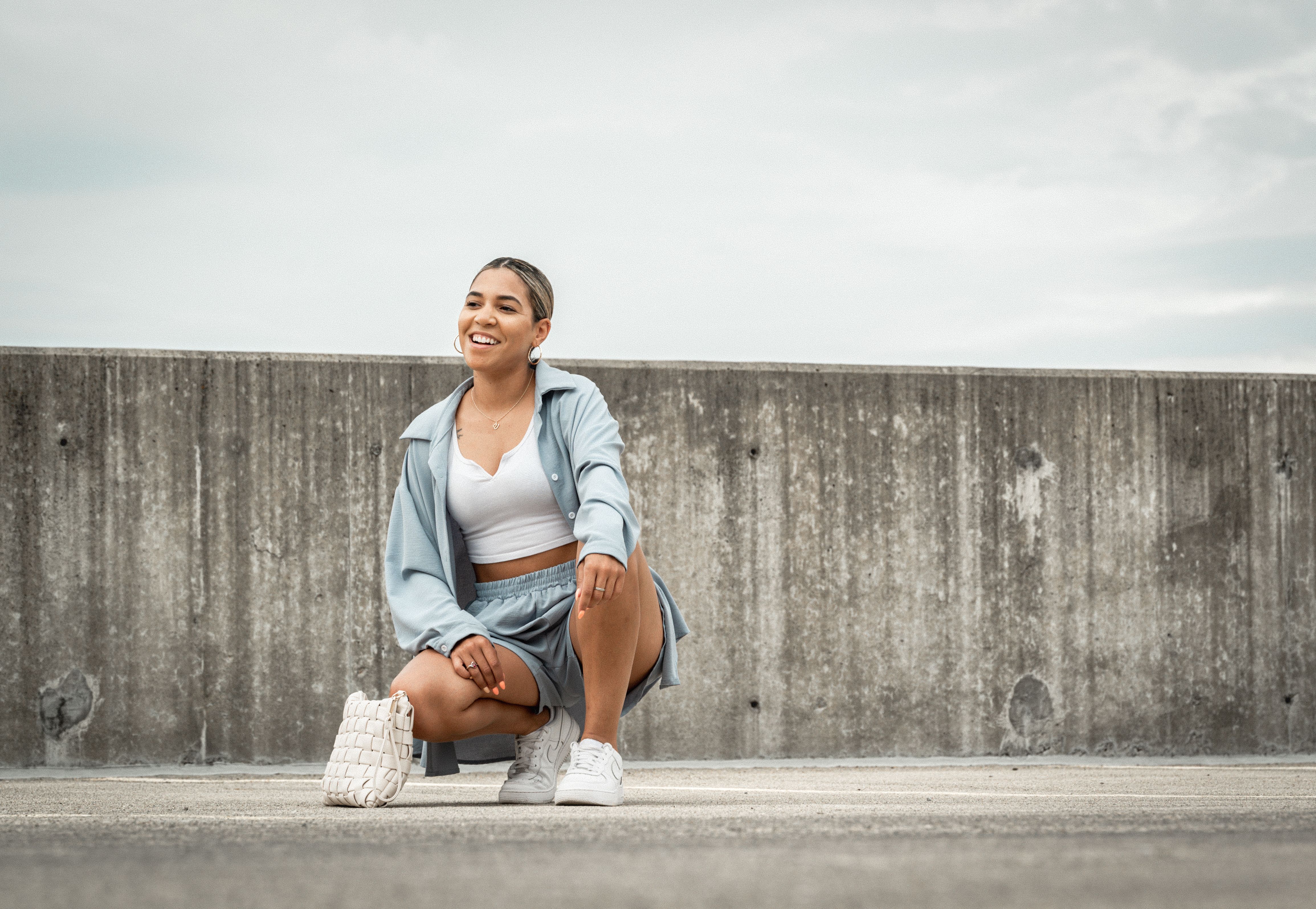 Smiling Woman Sitting Outdoors · Free Stock Photo