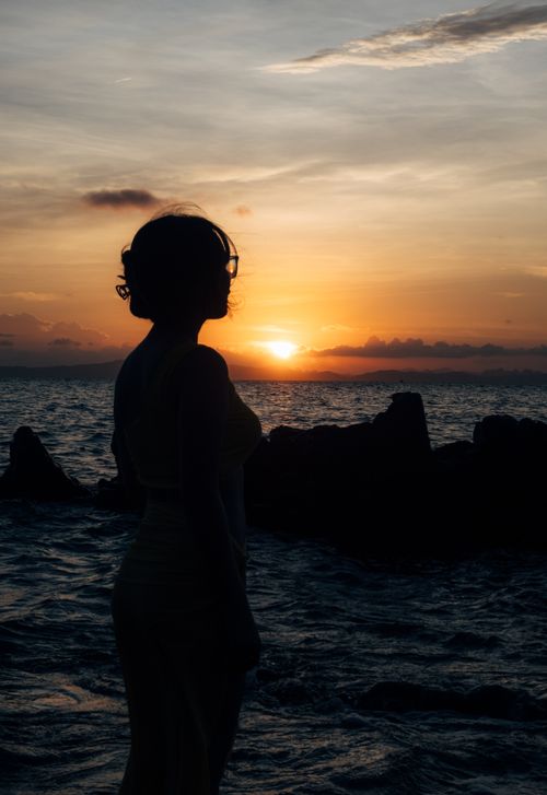 Free Silhouette of a woman by the sea against a stunning sunset in Quảng Ninh, Vietnam. Stock Photo