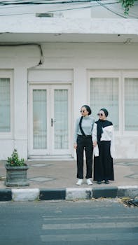 Two stylish women standing on an Indonesian street, showcasing contemporary fashion.