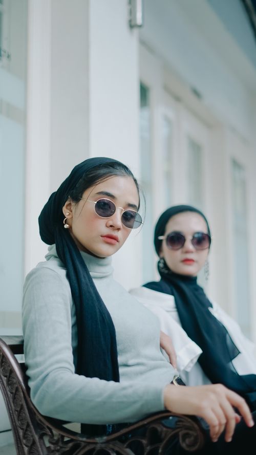 Free Two fashionable women with sunglasses and elegant attire in an outdoor setting in Indonesia. Stock Photo