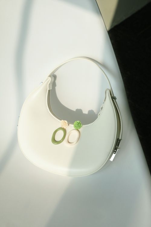 Free Chic white handbag on white surface with stylish earrings. A minimalist fashion accessory. Stock Photo