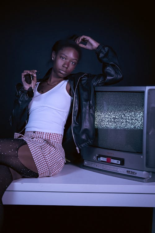 Female Fashion Model Posing Next to an Old-Fashioned Television Set