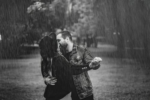 Grayscale Photo of a Romantic Couple Dancing in the Rain