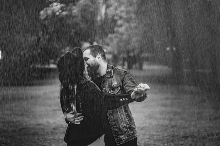 Grayscale Photo Of A Romantic Couple Dancing In The Rain