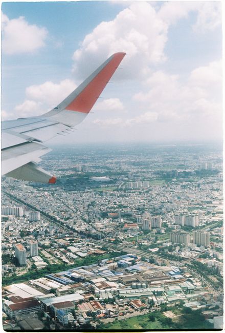 A stunning aerial view of a sprawling cityscape captured from an airplane window, showcasing urban density.