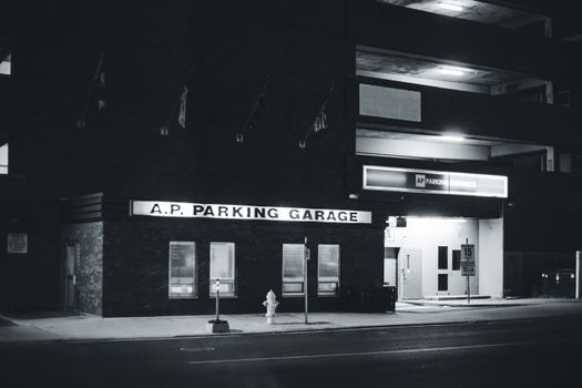 Nighttime view of A.P. Parking Garage in a city setting, black and white.