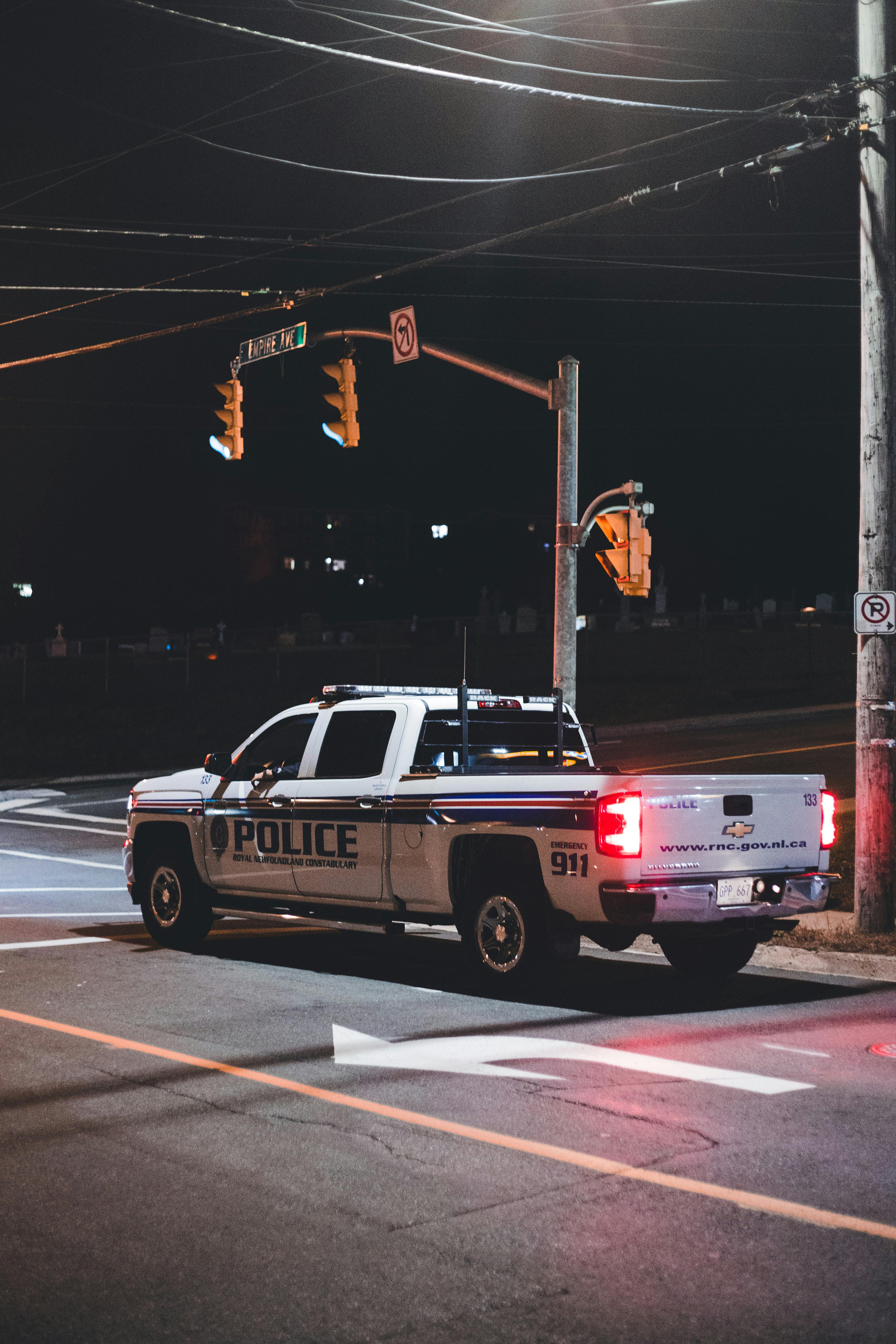 Police Car Waiting in Front of a Stoplight at Night · Free Stock Photo