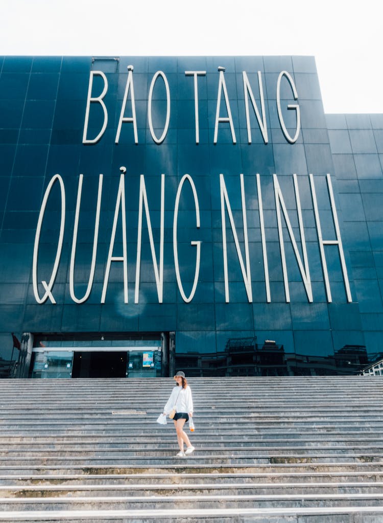 Young Woman Walking Down Steps In Front Of The Bao Tang Quang Ninh Museum