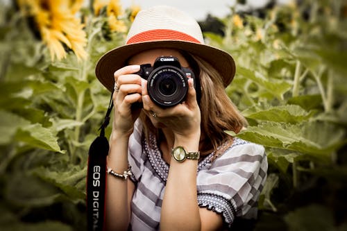 Fotografia Di Messa A Fuoco Selettiva Della Donna Che Tiene La Fotocamera Dslr