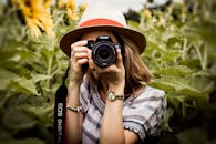 Selective Focus Photography of Woman Holding Dslr Camera