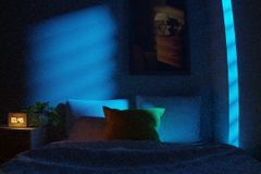 A dimly lit bedroom with neon blue lights and modern decor creates a calming nighttime atmosphere.