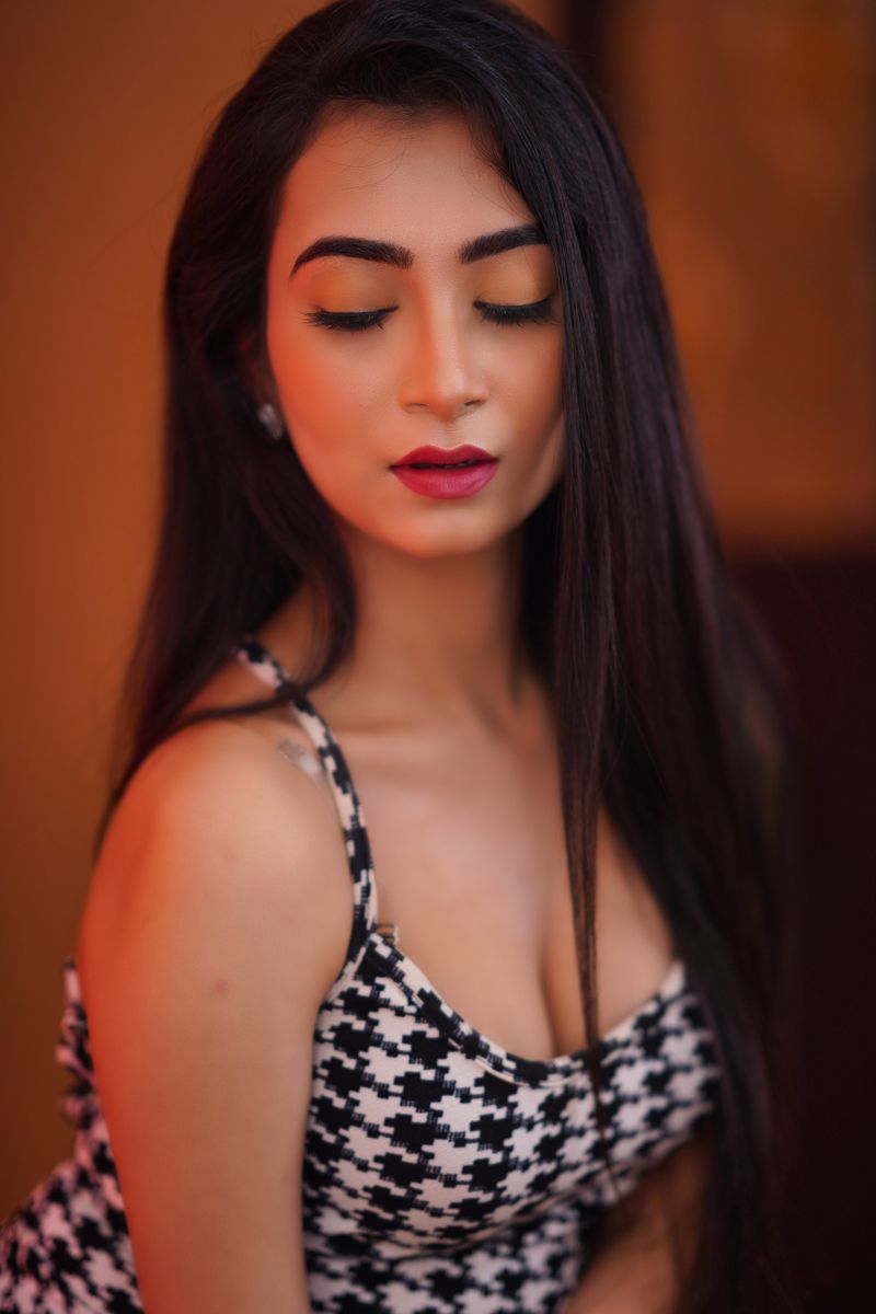 Serene brunette woman in stylish clothing, artistically captured indoors.