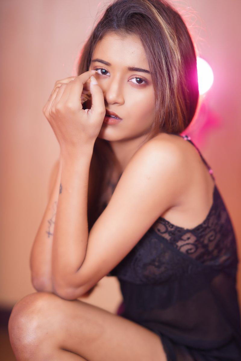 A captivating portrait of a woman posing indoors in black lingerie, exuding elegance and allure.