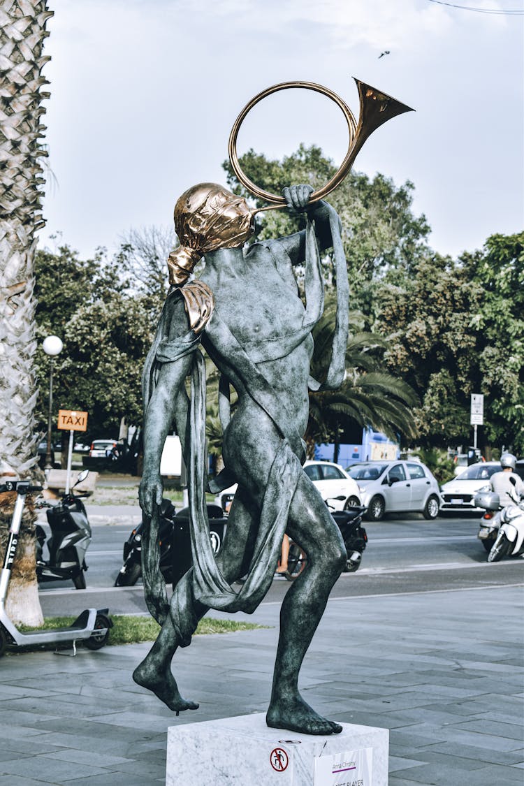 Cars And Sculpture On City Street