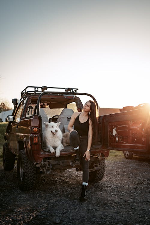Woman and a Dog Sitting on a Jeep