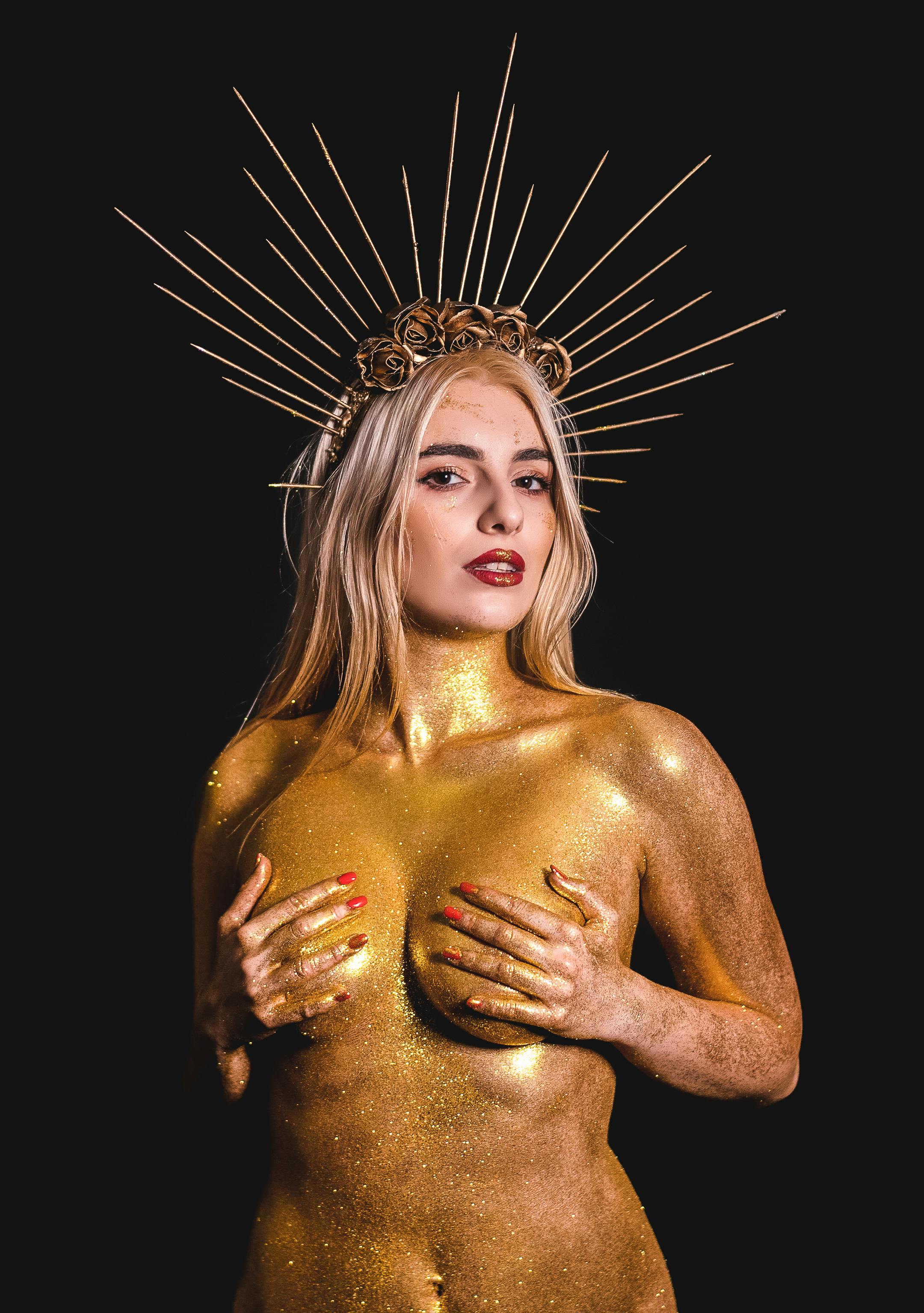 woman covered in golden glitter wearing a crown
