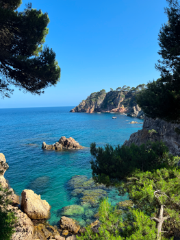 Breathtaking seaside landscape of Costa Brava with clear blue waters and rocky cliffs.