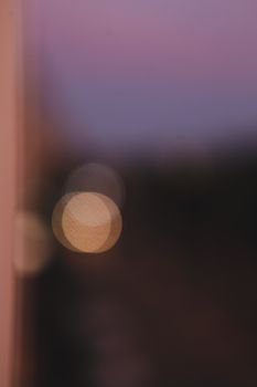 Abstract bokeh lights in a defocused image at twilight, creating a dreamy atmosphere.