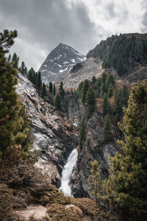 Free Discover the scenic waterfall amidst pine trees in Obergurgl, Tyrol, Austria. Stock Photo