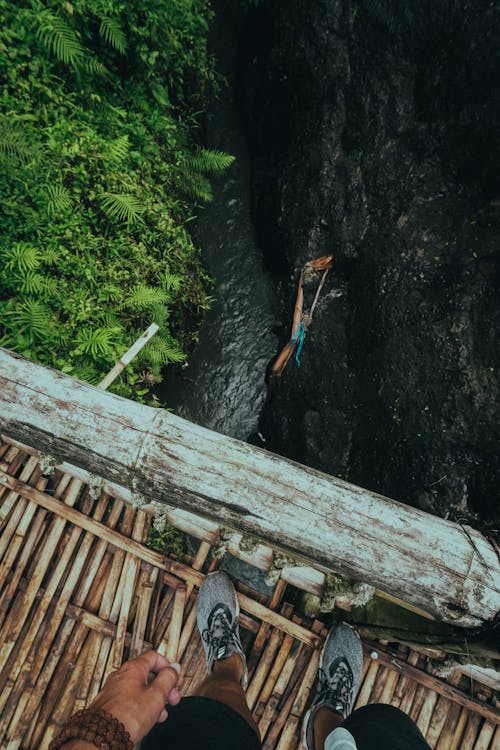 High-Angle Shot of a Person Standing on Wooden Bridge