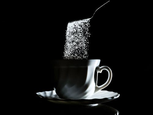 Sugar Falling into Coffee Cup