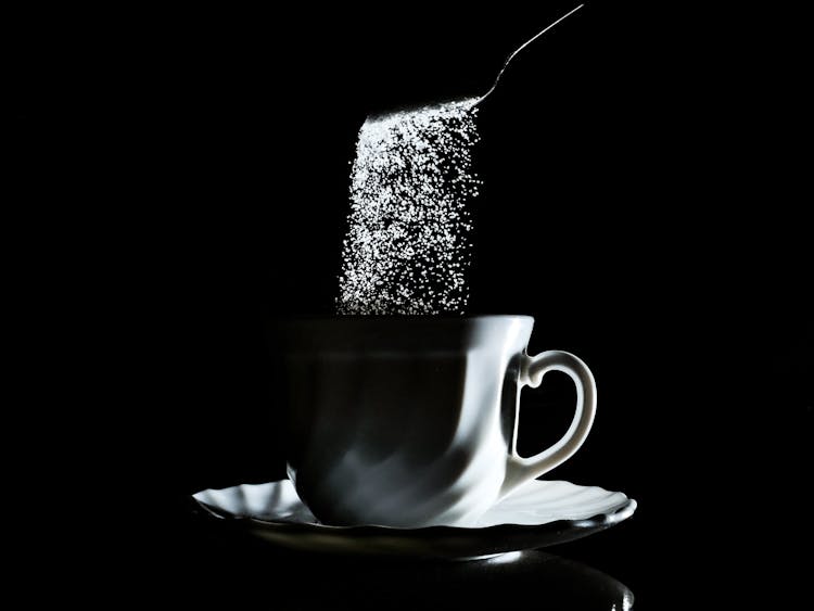 Sugar Falling Into Coffee Cup