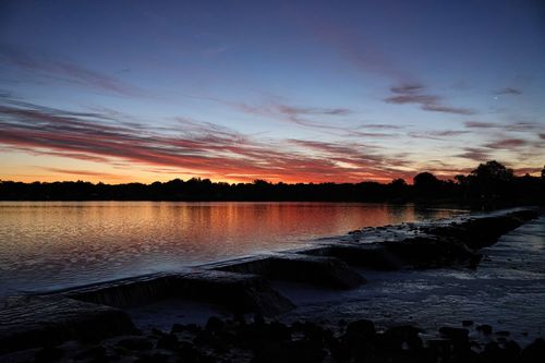 Free Captivating sunset reflecting over a calm lake in Stamford, showcasing vibrant colors and serene beauty. Stock Photo