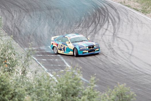 Colorful race car performs a dramatic drift on a winding track in Lithuania.