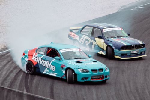 Free High-speed drift racing captured on a Lithuanian racetrack, showcasing skillful maneuvers and vibrant vehicles. Stock Photo
