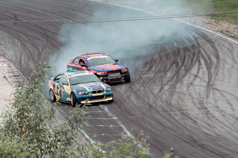 A tuned car throwing smoke through a corner during a drift event