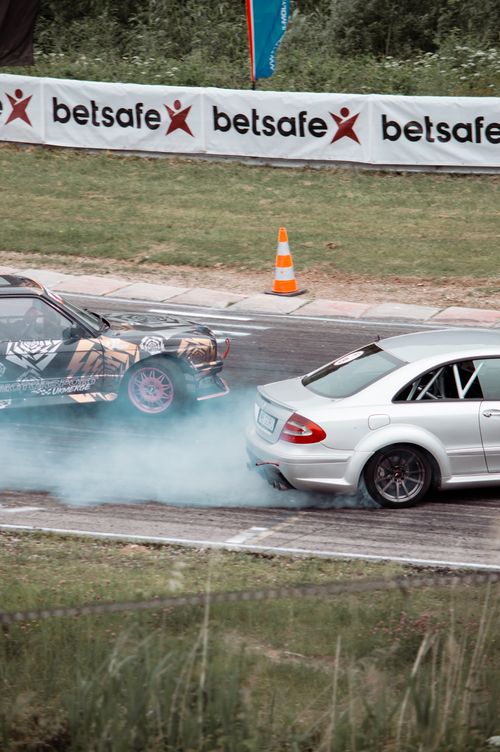 Free Two cars drifting on a racetrack in Lithuania, creating thrilling smoke trails. Stock Photo