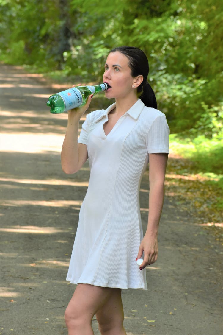 Woman Drinking From A Green Bottle