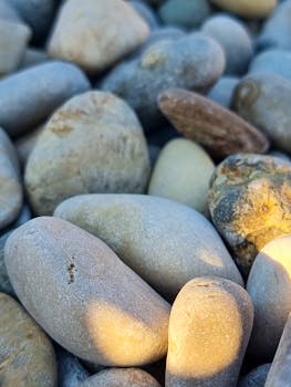 A detailed and vibrant shot of smooth stones and pebbles showcasing natural textures and light.