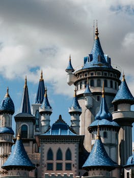 Stunning architectural design of a fantasy castle with blue turrets against a clear sky.