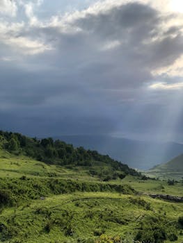 Explore the verdant landscapes of Keger, Dagestan, under a striking cloudy sky. Perfect for nature photography enthusiasts.