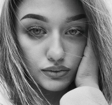 Striking black and white close-up portrait of a young woman in Kyiv, displaying serene expression.