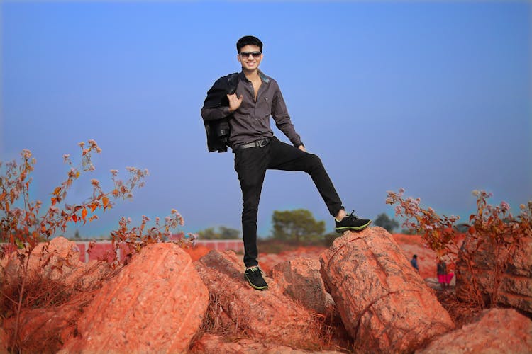 Man In Button Down Shirt Standing On Rocks